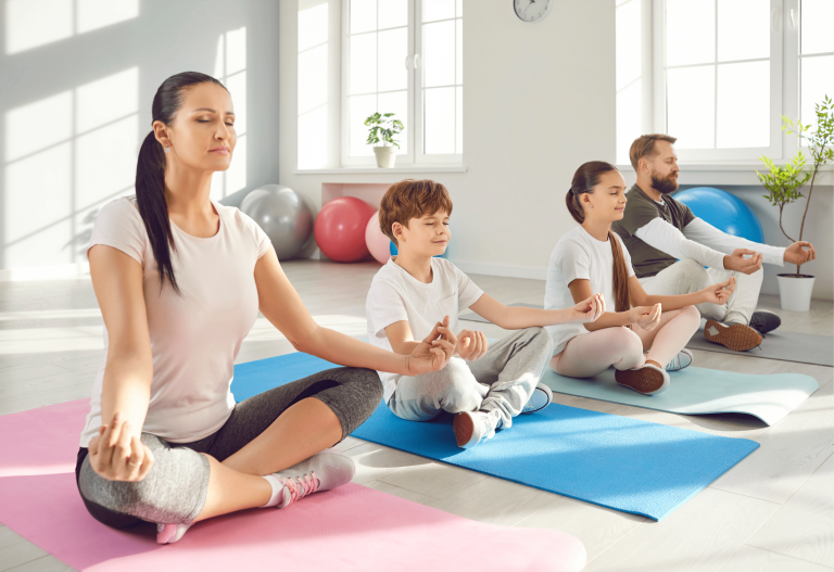 Family practicing yoga with two young children in Columbus, Ohio yoga studio